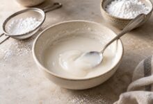 Weißer Zuckerguss in einer Keramikschale mit Löffel – mit KI erstellt [Bildinhalt mit KI erstellt]